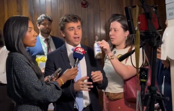 Sâmia entrega óleo de peroba a Nikolas Ferreira durante entrevista