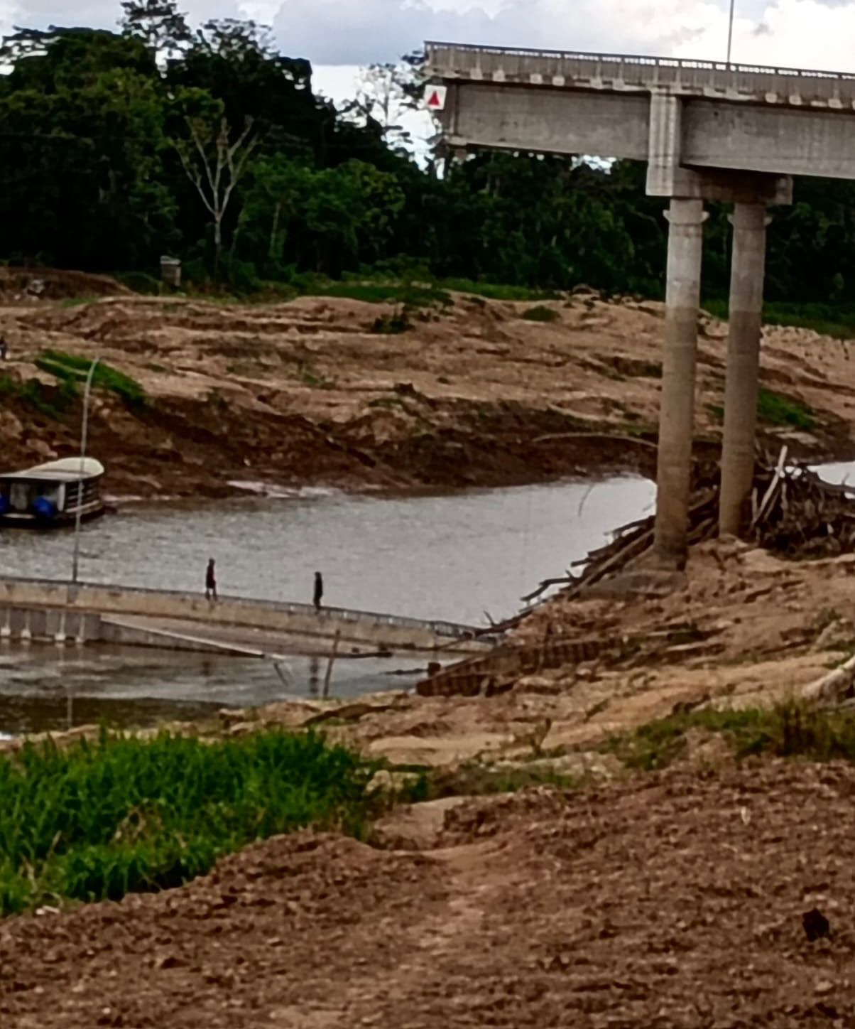pessoas caminham sobre destroços da ponte de Sena